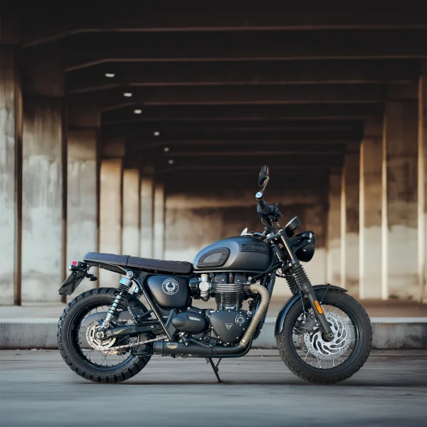 Triumph Bonneville T100 ACE Edition in Matt-Schwarz, seitliche Ansicht mit klassischem Zweizylinder-Motor, Doppelfederbeinen und Speichenrädern - aufgenommen bei MotoPassion in Emmering bei München.